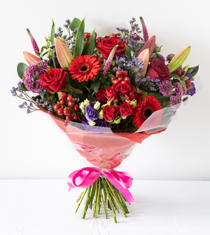 Tracey Hand-Tied - Romantic and passionate floral arrangement. Red, Pink and Purple - traditional and timeless. A classic hand-tied bouquet with an array of classic roses, Lisianthus and Lily's  - same day delivery in Bournemouth.