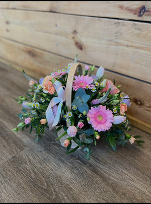 Bouquet of flowers with a basket on a wooden surface