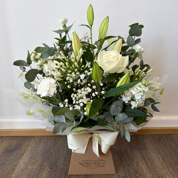 Bouquet of flowers with a Hillyview label on a wooden floor.
