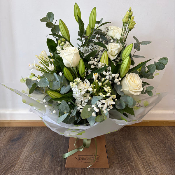 Bouquet of flowers with a card on a wooden surface