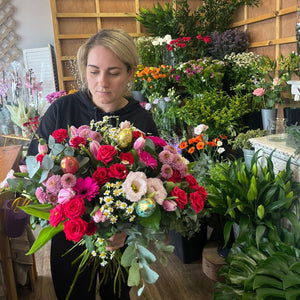 Woman holding a bouquet of flowers in a floral shop