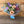 Load image into Gallery viewer, A vibrant mixed flower bouquet wrapped in clear cellophane and tied with a light blue ribbon, set against a rustic wooden plank background.
