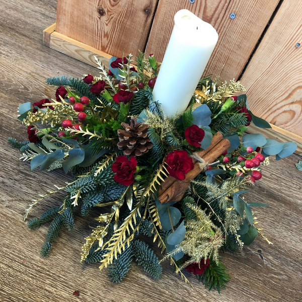 Traditional Christmas Table Decoration with a Candle. Festive foliage and flower arrangement. Same day delivery in Bournemouth.