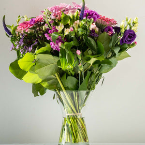 Hayley Vase - Soft, pretty and delicate lilac floral arrangement of Lisianthus, long lasting Carnations, Alstromeria and Liminioum. Seasonal bouquet displayed in a vase for same day delivery in Bournemouth.