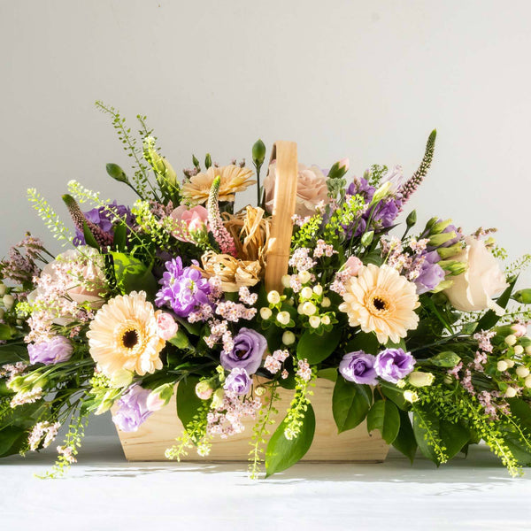 Sophie Basket - elegant, calm and relaxing pastel bouquet with Freesia, handpicked Delphinium and soft foliage. Displayed in a basket for same day delivery in Bournemouth.