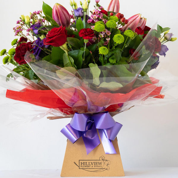 Tracey Aqua Pack - Romantic and passionate floral arrangement. Red, Pink and Purple - traditional and timeless. A classic bouquet with an array of classic roses, Lisianthus and Lily's in an aqua pack - same day delivery in Bournemouth.