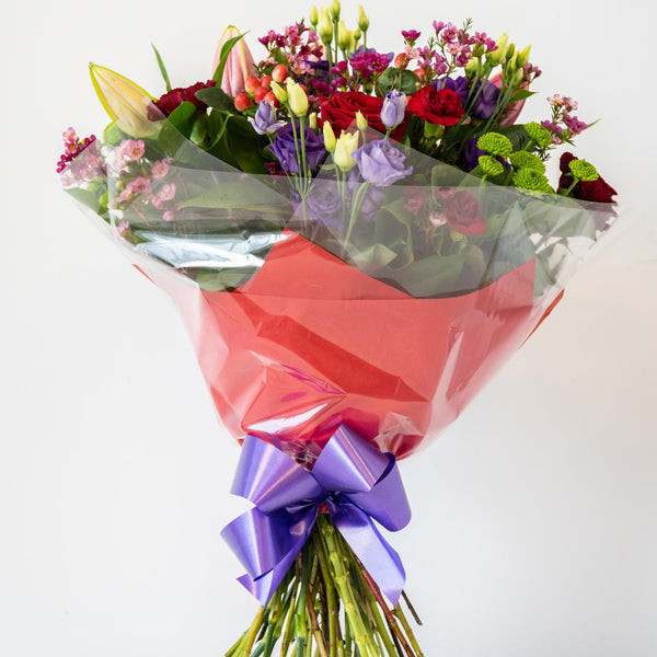 Tracey Hand-Tied - Romantic and passionate floral arrangement. Red, Pink and Purple - traditional and timeless. A classic hand-tied bouquet with an array of classic roses, Lisianthus and Lily's  - same day delivery in Bournemouth.