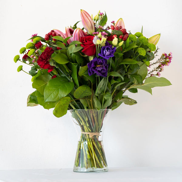 Tracey Vase - Romantic and passionate floral arrangement. Red, Pink and Purple - traditional and timeless. A classic bouquet with an array of classic roses, Lisianthus and Lily's in a vase - same day delivery in Bournemouth.